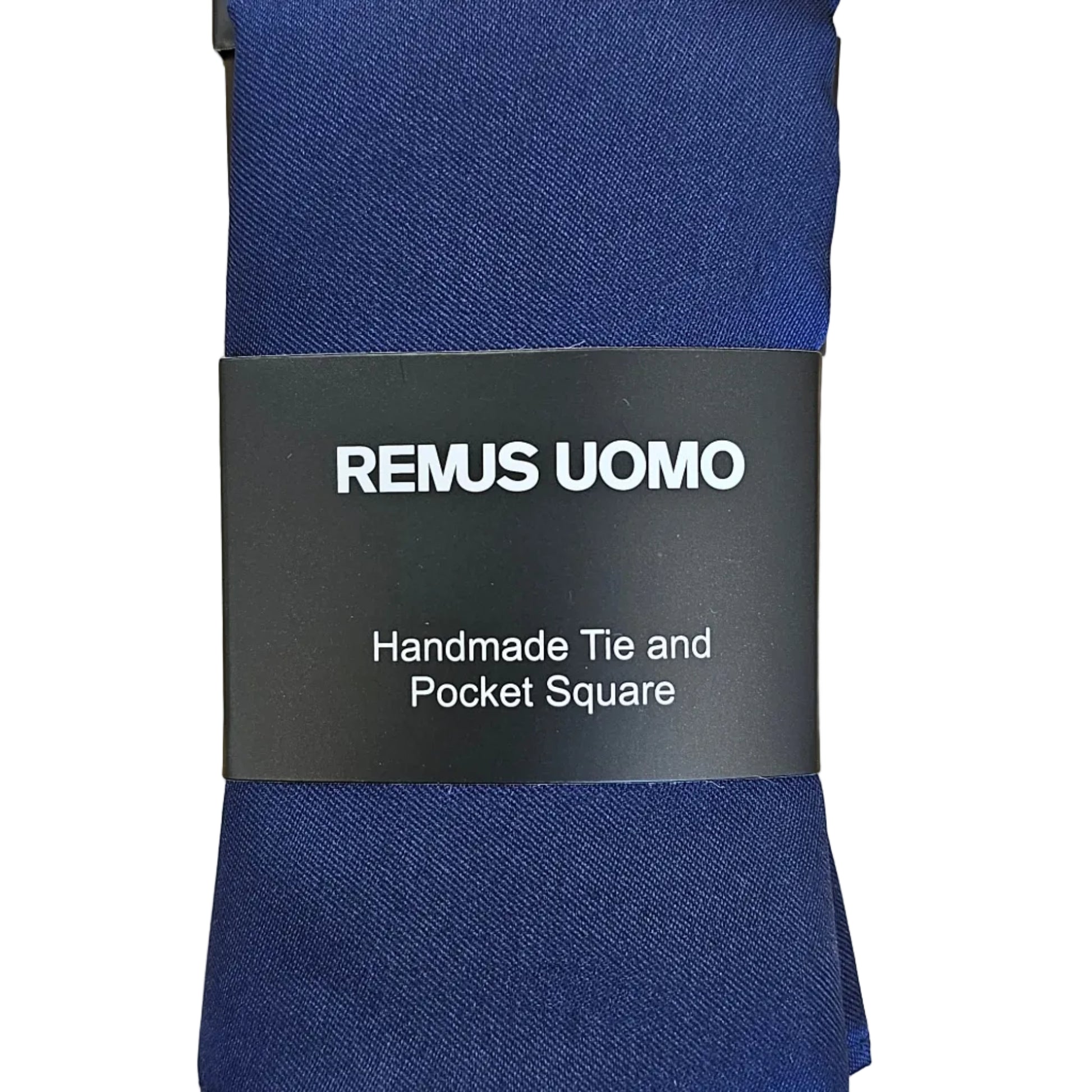 A navy blue square tie wrapped in a black paper band labeled 'REMUS UOMO', placed on a light wood grain surface.