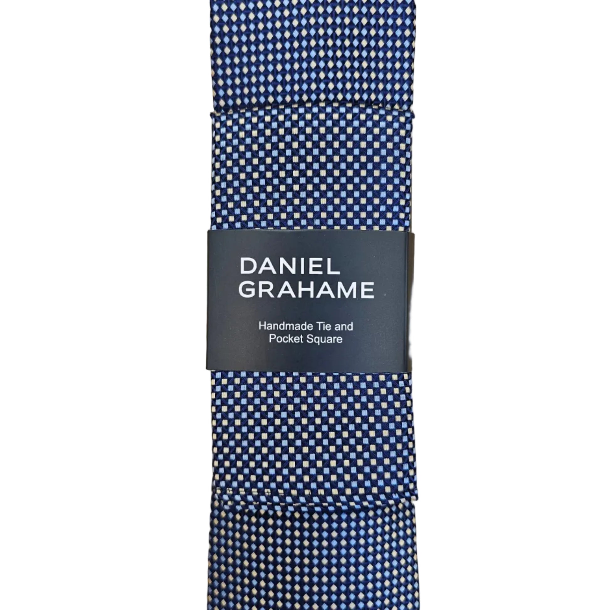 A folded Daniel Grahame tie with a blue and white micro-check pattern, wrapped in a black paper band with white text, set against a light wood grain background.