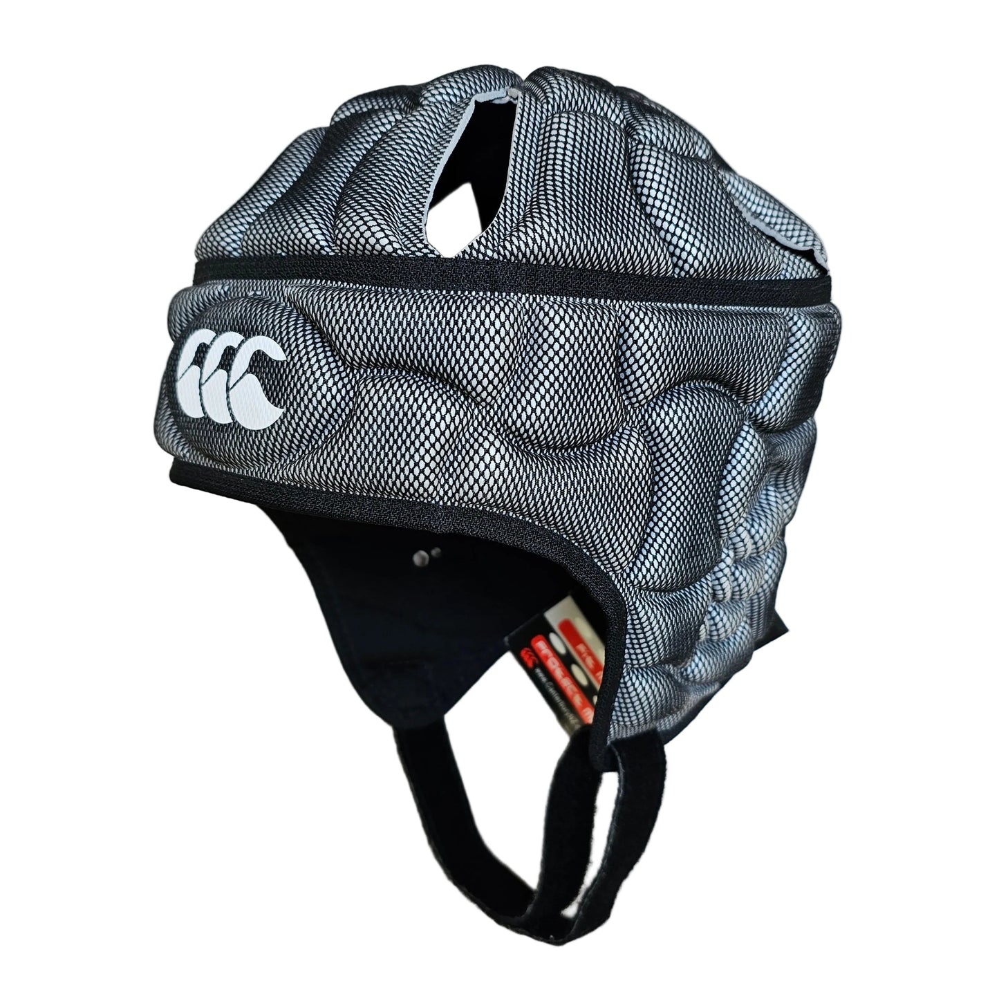 A black and gray mesh rugby helmet with white Canterbury logo, shown on a light wood floor.