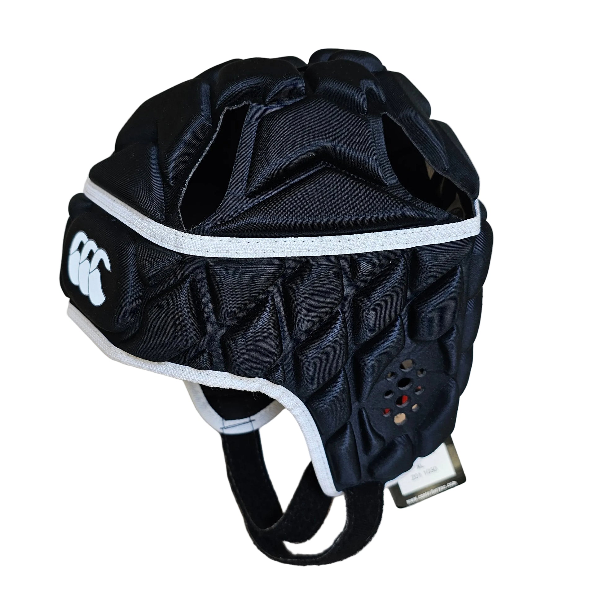 A black rugby helmet protector with white trim and a white Canterbury logo, displayed on a light wood floor.