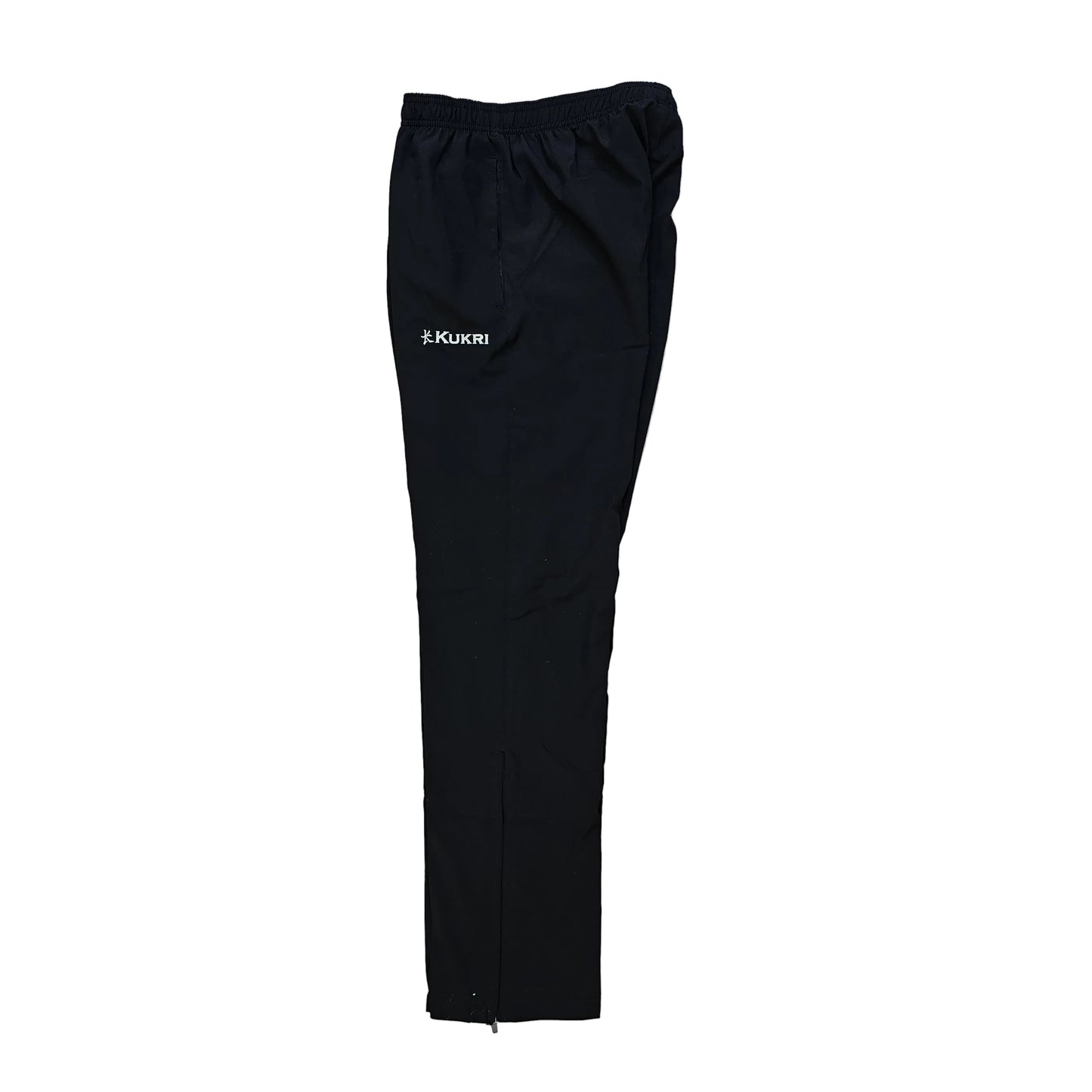 Black athletic pants with an elastic waistband and a small white logo on the left thigh, laid flat on a light wood floor.