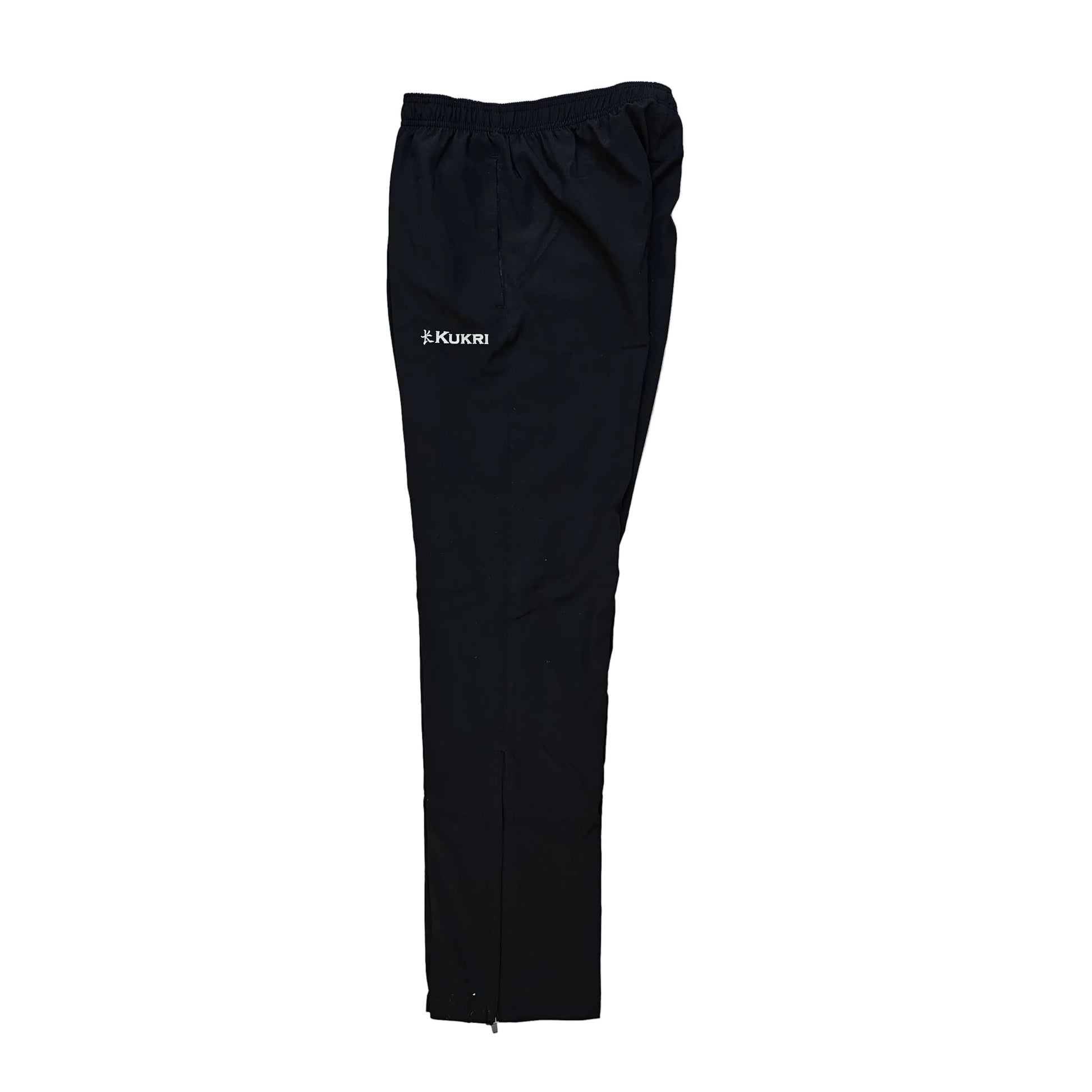Black athletic pants with an elastic waistband and a small white logo on the left thigh, laid flat on a light wood floor.